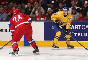TORONTO, CANADA - JANUARY 4: Sweden's Christoffer Ehn #26 skates with the puck while Russia's Rinat Valiev #24 defends during semifinal action at the 2015 IIHF World Junior Championship. (Photo by Andre Ringuette/HHOF-IIHF Images)